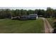 Scenic aerial view of the house, set amongst mature trees, green grass, a fence, and a long driveway at 2055 Cauble Rd, Salisbury, NC 28144