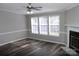 Bright living room featuring wood-look floors, fireplace, and three windows for ample natural light at 2055 Cauble Rd, Salisbury, NC 28144