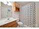 Well-lit bathroom featuring a vanity with a wooden cabinet and a shower with patterned curtain at 210 35Th Ne Ave, Hickory, NC 28601