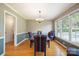 Dining room featuring hardwood floors, wainscoting, a chandelier, and natural light from large windows at 210 35Th Ne Ave, Hickory, NC 28601