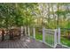 An outdoor deck area with wood flooring, white posts, and cable railing system with wooded area in the background at 210 35Th Ne Ave, Hickory, NC 28601