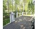An outdoor deck area with wood flooring, white posts, and cable railing system with trees in the background at 210 35Th Ne Ave, Hickory, NC 28601