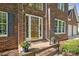 Close-up of the front door with a brick stoop decorated with colorful potted flowers at 210 35Th Ne Ave, Hickory, NC 28601