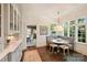 Bright breakfast nook featuring a custom built-in bench, marble table, and large windows overlooking the outdoors at 2101 Dilworth W Rd, Charlotte, NC 28203