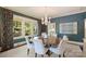 Elegant dining room featuring a round wood table, chandelier, and large windows with views of lush greenery at 2101 Dilworth W Rd, Charlotte, NC 28203