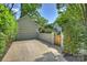 Long driveway leading to detached garage, framed by manicured landscaping and wooden gate at 2101 Dilworth W Rd, Charlotte, NC 28203