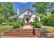 Traditional white home with brick stairs leading to the front door, surrounded by lush green landscaping at 2101 Dilworth W Rd, Charlotte, NC 28203