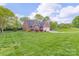 Beautifully landscaped yard surrounds this charming brick home with an expansive green lawn at 2104 Planters Knoll Dr, Monroe, NC 28110