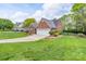 Beautifully landscaped yard surrounds this charming brick home with an expansive green lawn at 2104 Planters Knoll Dr, Monroe, NC 28110