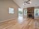 Bright living room featuring hardwood floors, a stone fireplace, and a modern ceiling fan at 2104 Planters Knoll Dr, Monroe, NC 28110
