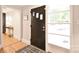 The entryway features hardwood floors, a window allowing for natural light, and a unique black front door at 2121 Arnold Dr, Charlotte, NC 28205