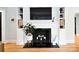 Close-up of the fireplace featuring built-in shelving, hardwood floors, and mantle decorations at 2121 Arnold Dr, Charlotte, NC 28205