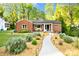 Charming brick home featuring a beautifully landscaped front yard with a stone walkway and lush greenery at 2121 Arnold Dr, Charlotte, NC 28205