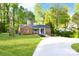 Charming single-story brick home features a lush lawn, mature trees, and a curved driveway at 2121 Arnold Dr, Charlotte, NC 28205