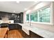 Well-lit kitchen featuring a large window, black cabinets, white marble countertops, and stainless appliances at 2121 Arnold Dr, Charlotte, NC 28205