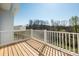 View of the outdoor patio area, surrounded by white railings and a scenic wooded vista at 2124 Barrowcliffe Nw Dr, Concord, NC 28027
