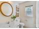 Well-lit bathroom featuring a classic round mirror and white fixtures at 2221 Hamilton Mill Rd, Charlotte, NC 28270