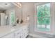 Bright bathroom featuring a marble floor, white vanity, and a window providing natural light at 2221 Hamilton Mill Rd, Charlotte, NC 28270