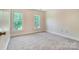 Light-filled bedroom with neutral walls, plush carpeting, and two windows offering serene views at 2221 Hamilton Mill Rd, Charlotte, NC 28270