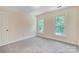 Comfortable bedroom with neutral walls, carpeting, and natural light from two windows at 2221 Hamilton Mill Rd, Charlotte, NC 28270