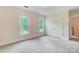 Well-lit bedroom with neutral walls, carpet, two windows, and a double-door closet for storage at 2221 Hamilton Mill Rd, Charlotte, NC 28270