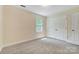 Bedroom featuring neutral walls, carpeting, a window, and a double-door closet for ample storage at 2221 Hamilton Mill Rd, Charlotte, NC 28270