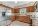 Well-lit kitchen with stainless steel appliances, wood cabinets, granite countertops, and tiled floors at 2221 Hamilton Mill Rd, Charlotte, NC 28270