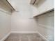 A simple, carpeted walk-in closet with bars for hanging clothing at 2221 Hamilton Mill Rd, Charlotte, NC 28270
