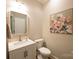 A clean half bathroom features a decorative mirror and floral artwork at 260 Ingonish Dr, Gastonia, NC 28056