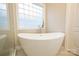 Soaking tub in a bright bathroom with a large window and a glass shower at 260 Ingonish Dr, Gastonia, NC 28056