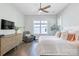 Bright bedroom with wood floors, ceiling fan, sitting area, and large window with natural light at 3012 Laney Pond Rd, Matthews, NC 28104