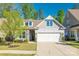 Charming home with stone accents, a two-car garage, and well-maintained landscaping on a sunny day at 3012 Laney Pond Rd, Matthews, NC 28104