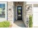 Close-up of the front door with stone surround, modern light fixtures, and clear address numbers at 3012 Laney Pond Rd, Matthews, NC 28104
