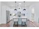 Modern kitchen with white cabinets, a stainless steel refrigerator, and an island with seating at 3012 Laney Pond Rd, Matthews, NC 28104