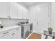 Clean and well-lit laundry room featuring modern washer and dryer units and storage cabinets at 3012 Laney Pond Rd, Matthews, NC 28104