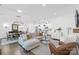 Open-concept living room with ample seating, modern lighting, and hardwood floors at 3012 Laney Pond Rd, Matthews, NC 28104
