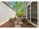 Landscaped side yard with stone pathway leading to a seating area with table and chairs at 3012 Laney Pond Rd, Matthews, NC 28104