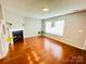 Bright living room featuring a fireplace, hardwood floors, and a large window at 3129 Brockhampton Ct, Charlotte, NC 28269