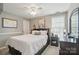 Cozy bedroom features a comfortable bed, a ceiling fan, and a window letting in natural light at 3131 Arborhill Rd, Charlotte, NC 28270