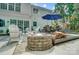 Outdoor patio area featuring a brick fire pit, comfortable seating, and a dining table under a blue umbrella at 3131 Arborhill Rd, Charlotte, NC 28270