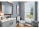 Stylish powder room featuring a decorative mirror, modern vanity, and ample natural light at 3131 Arborhill Rd, Charlotte, NC 28270