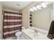 Bathroom features shower with striped curtain, vanity, mirror and modern light fixture at 3335 Hawick Commons Dr, Concord, NC 28027