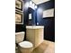 Chic powder room with dark blue walls, framed artwork, and modern fixtures at 3718 Barclay Downs Dr, Charlotte, NC 28209