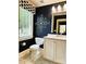 Stylish powder room with dark blue walls, white vanity, and elegant fixtures at 3718 Barclay Downs Dr, Charlotte, NC 28209