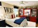 Comfortable bedroom featuring a bed, ceiling fan, and custom red shelving at 3718 Barclay Downs Dr, Charlotte, NC 28209