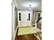 Welcoming foyer with hardwood floors, a bright doorway, and a staircase to the upper level at 3718 Barclay Downs Dr, Charlotte, NC 28209