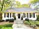 Charming home featuring a beautifully landscaped front yard, black shutters, and a welcoming stone pathway at 3718 Barclay Downs Dr, Charlotte, NC 28209