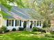 Beautiful landscaped front yard of home with black shutters, and a stone pathway at 3718 Barclay Downs Dr, Charlotte, NC 28209