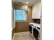 Functional laundry room with modern appliances, built-in cabinets, and a window for natural light at 3718 Barclay Downs Dr, Charlotte, NC 28209