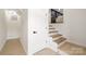Basement stairs leading to a living area, with white walls and light wood treads at 3801 Woodleaf Rd, Charlotte, NC 28205
